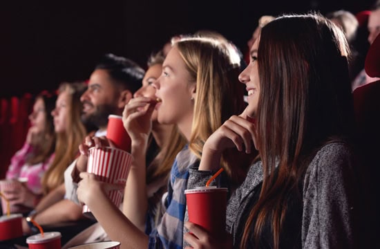 Kinozuschauer mit Popcorn und Trinken in der Hand