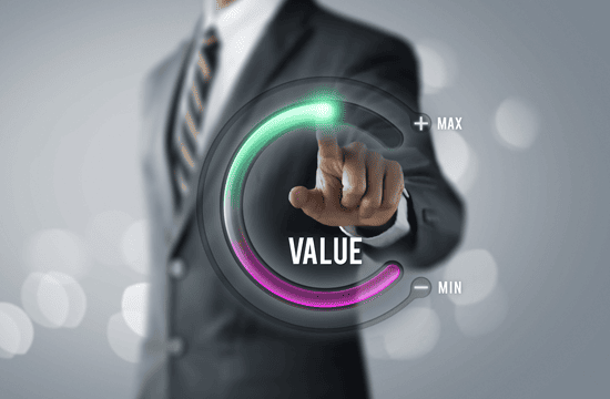 Ein Mann zeigt bei einer Werteskala auf max. Er signalisiert den Mehrwert bzw. USP im Marketing durch Strategie und Beratung.